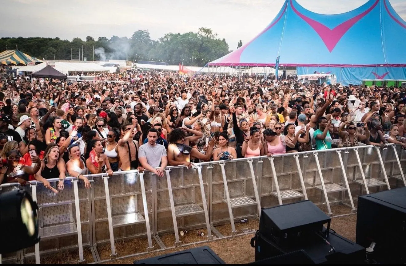 Large festival crowd gathered in front of a colourful outdoor stage